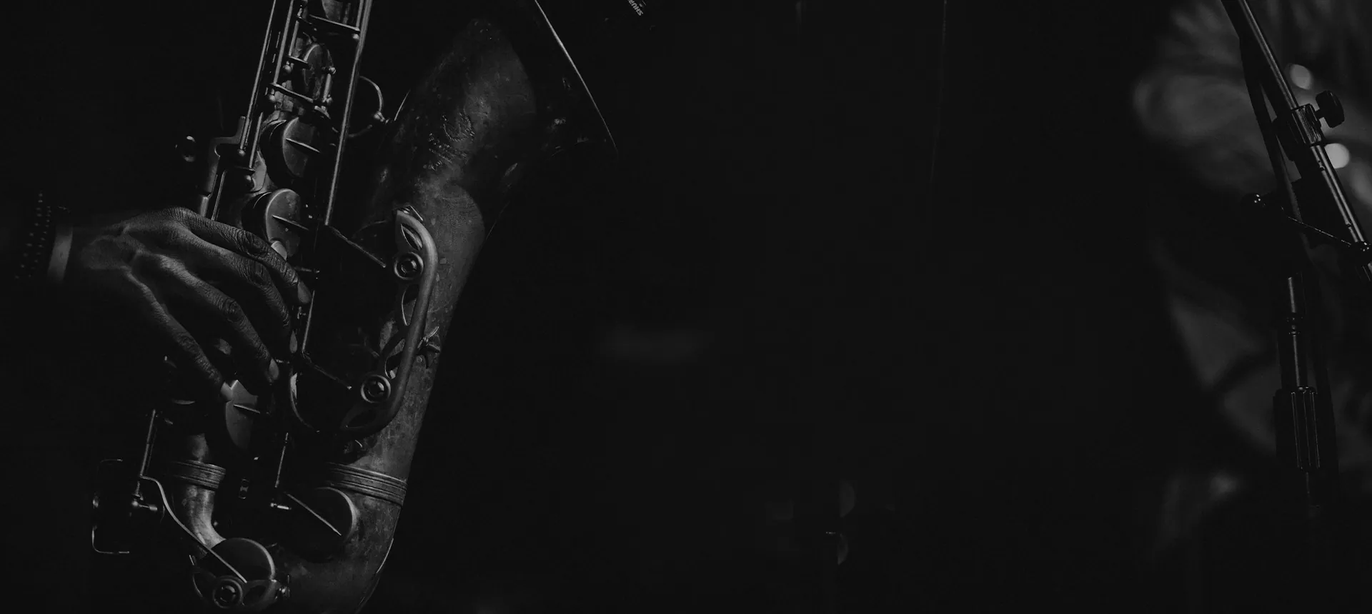 A saxophonist performing on a dark stage